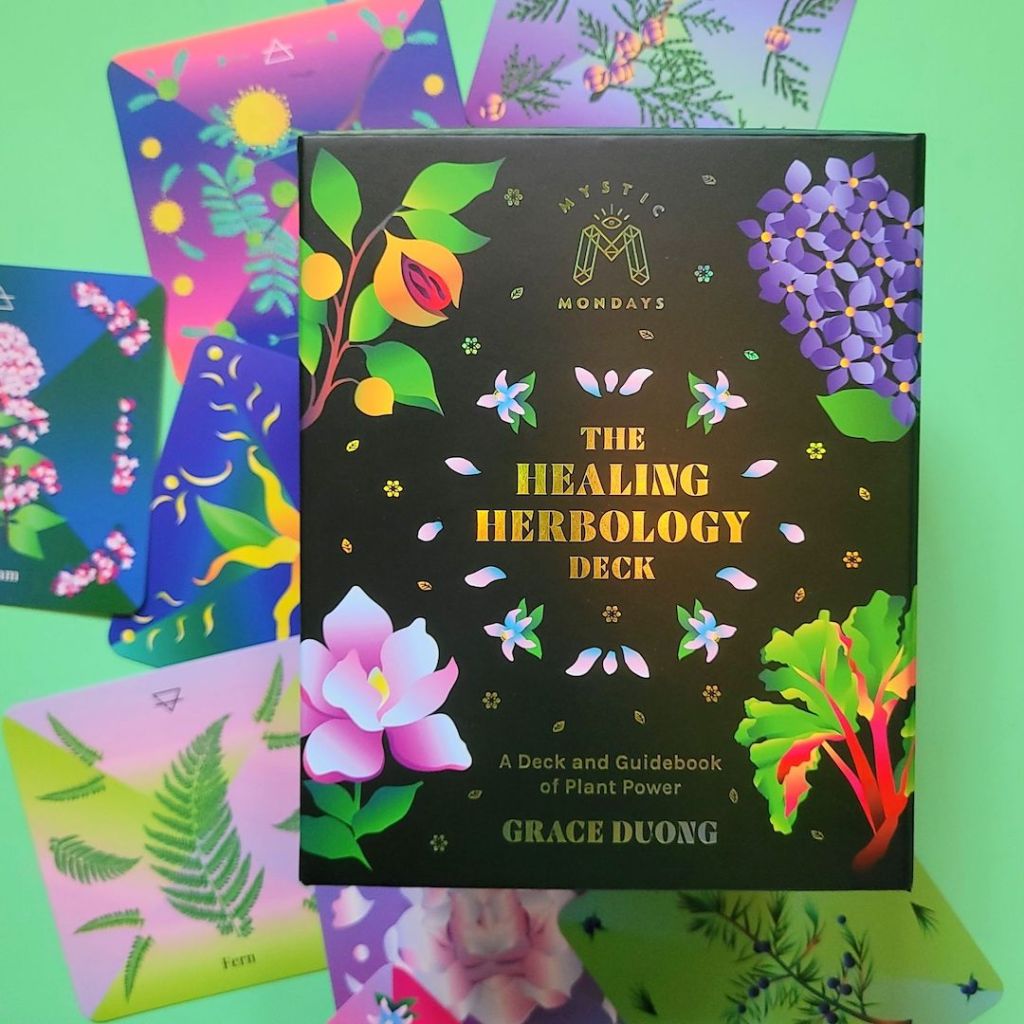 Photo of the Mystic Mondays The Healing Herbology Deck box next to face up cards from the deck.